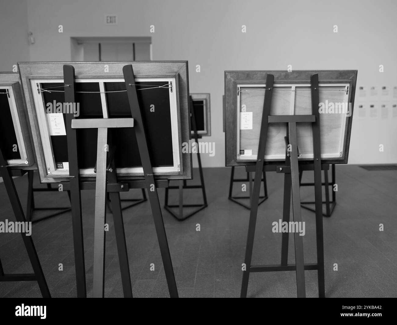 Monochrome image of wooden easels at a museum art exhibit seen from ...
