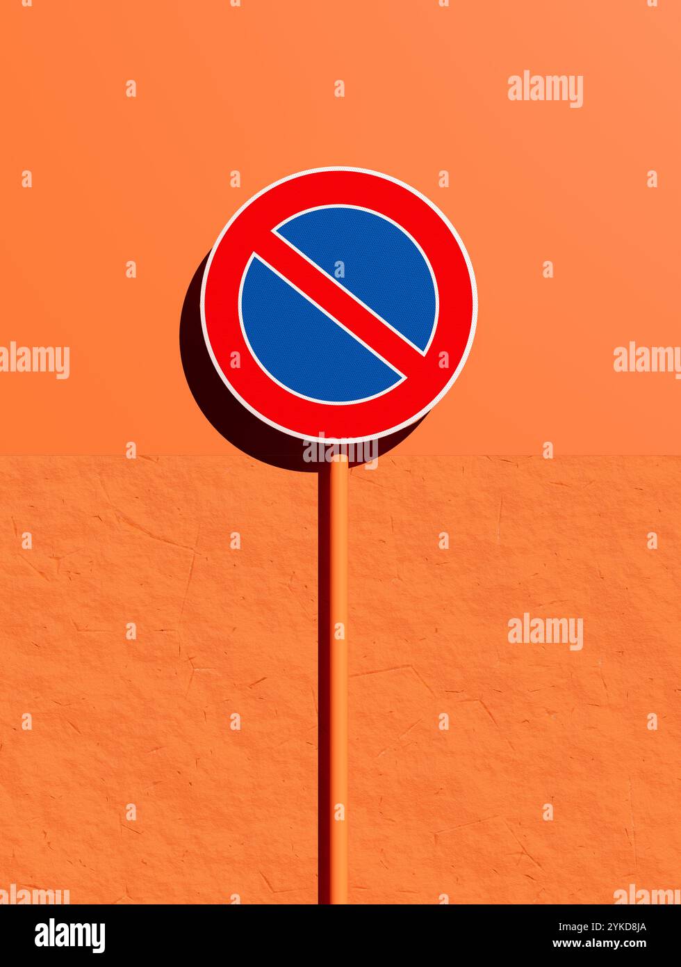 Red and blue no parking sign on a vibrant orange wall, conveying a ...