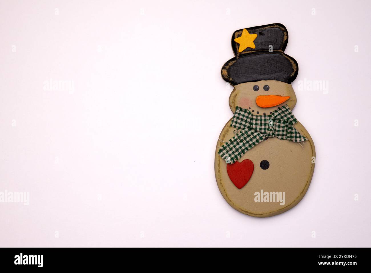 A delightful snowman decoration showcases a smiling face with a hat and bow, perfect for winter and holiday celebrations. Stock Photo