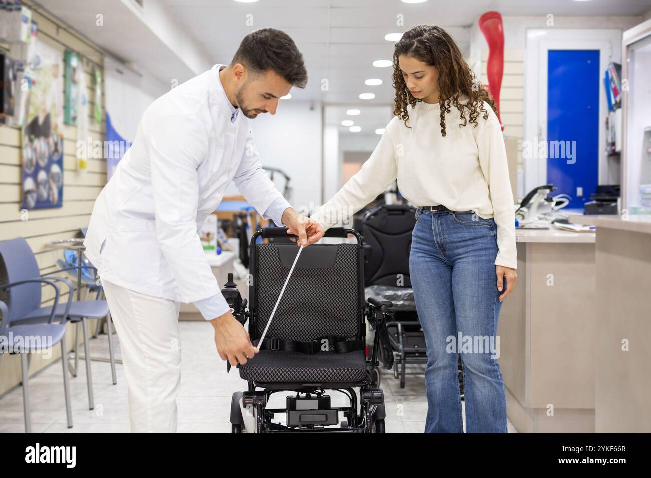 A professional measures wheelchair dimensions in an orthopedic supply ...