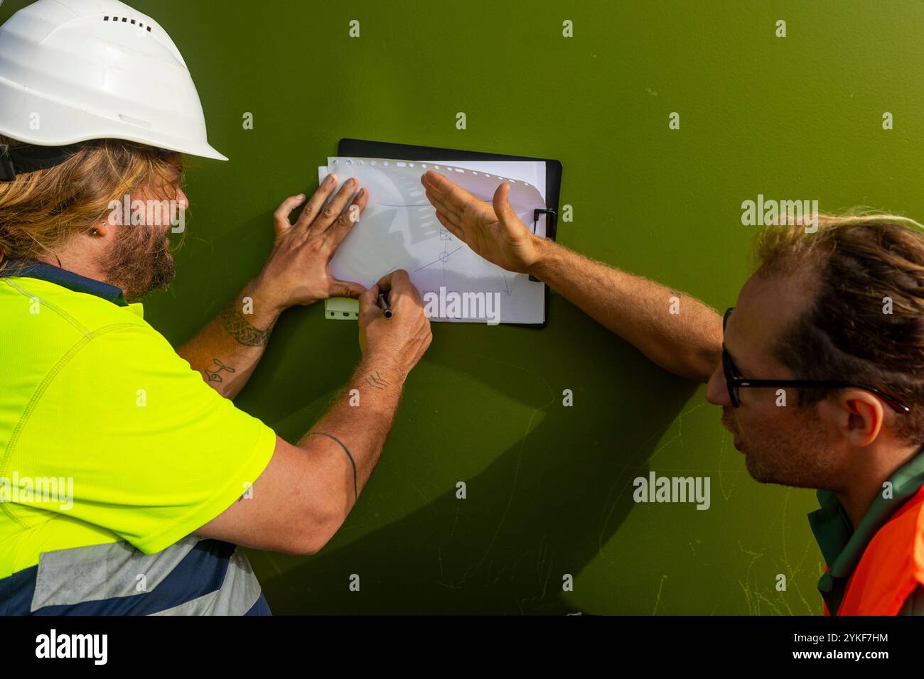 A disabled inspector collaborates with a colleague to review technical ...