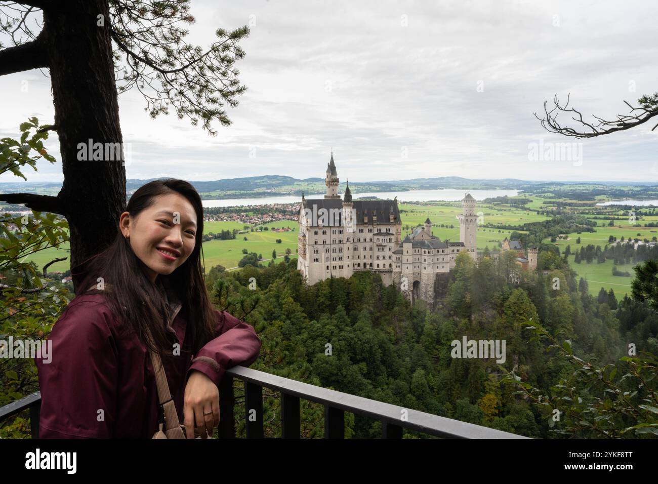 A smiling Asian woman looking at the camera from a viewpoint ...