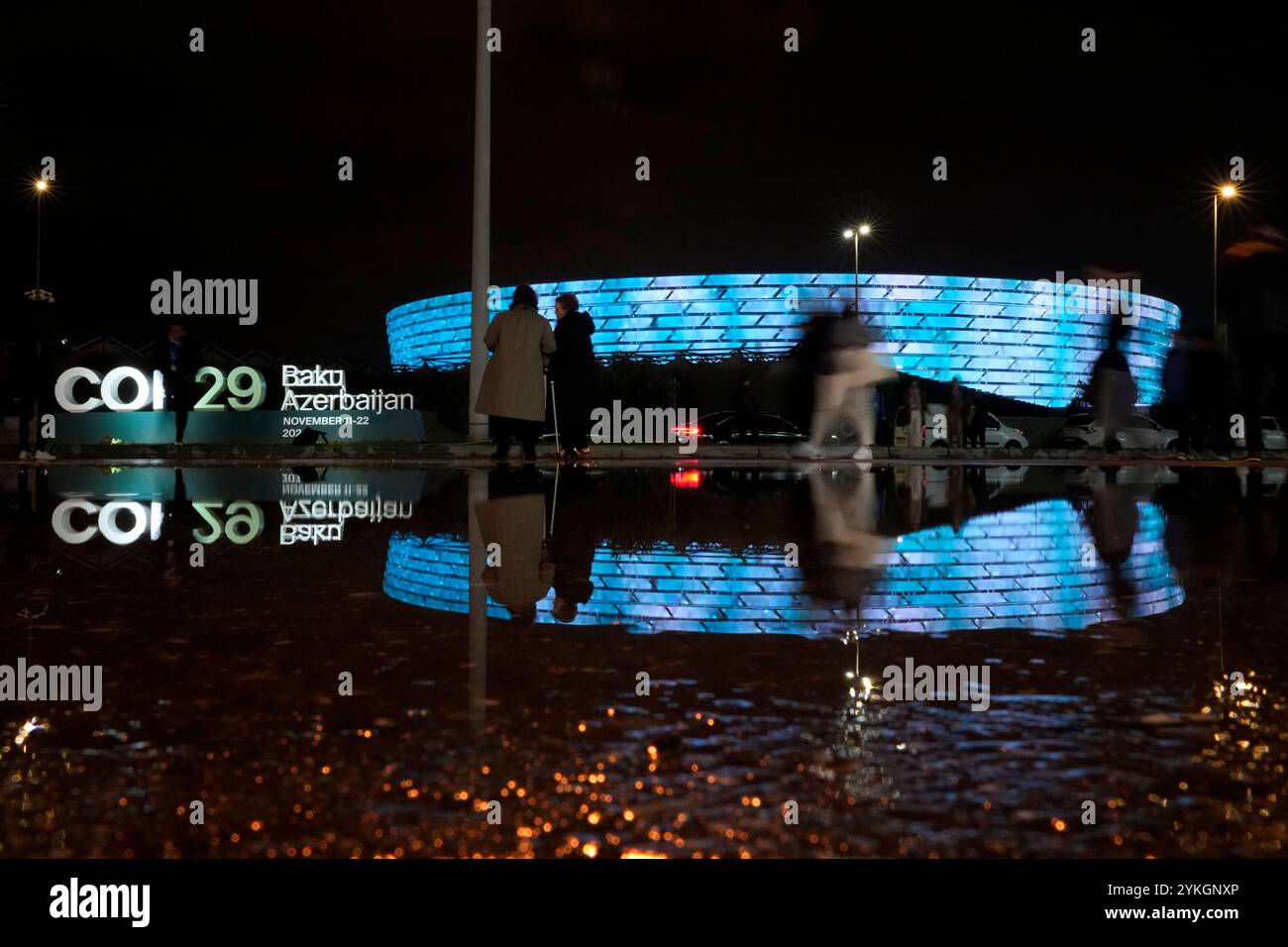 People walk with the Baku Olympic Stadium in the background, the venue ...