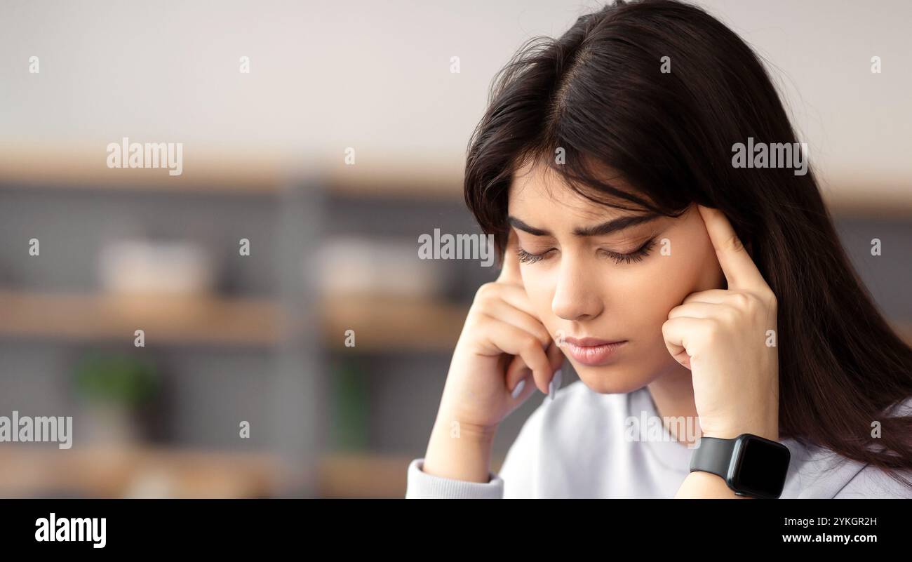 Tired woman massaging temples sitting at desk with laptop Stock Photo ...