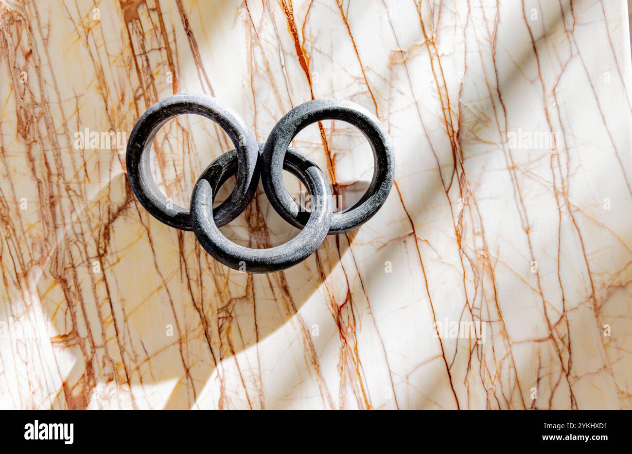 three round links attached and displayed on a marble background Stock Photo