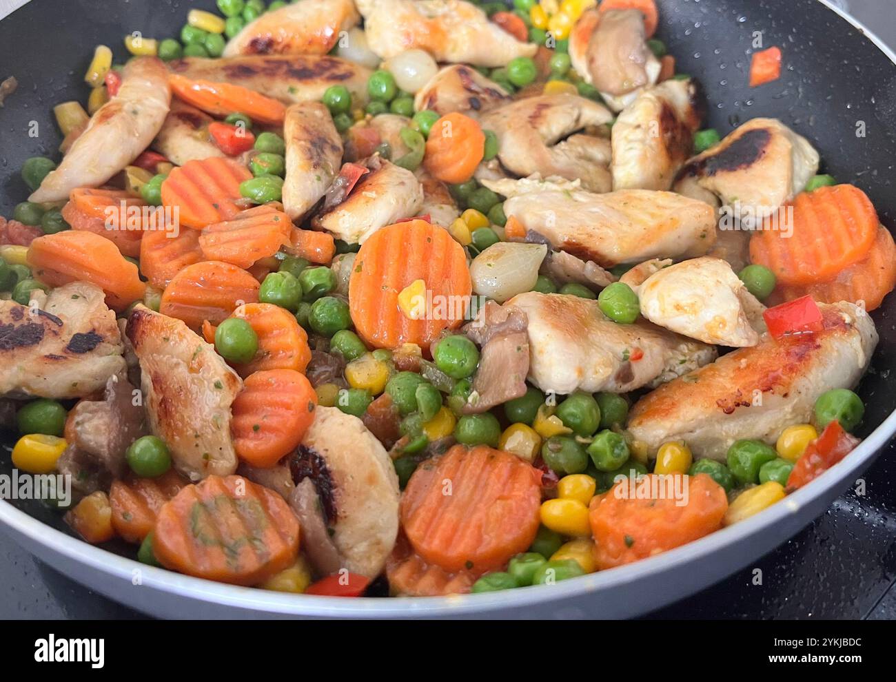 Cooked chicken and mixed vegetables in frying pan simple homemade cooking dish - Smartphone Captured Stock Image