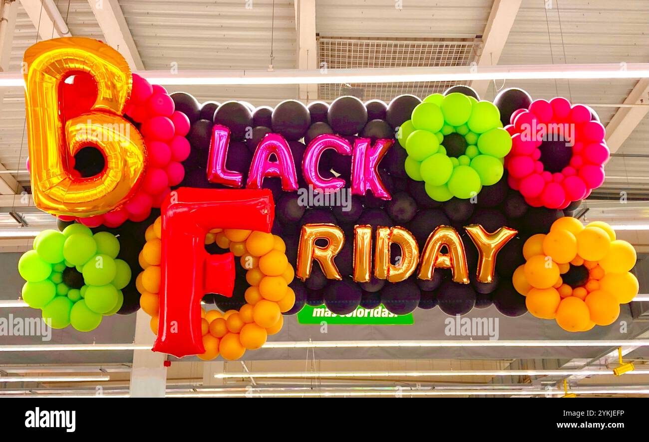 Large colourful floral Black Friday sign made from inflated balloons hanging from the ceiling in a warehouse style store - Smartphone Captured Stock Image