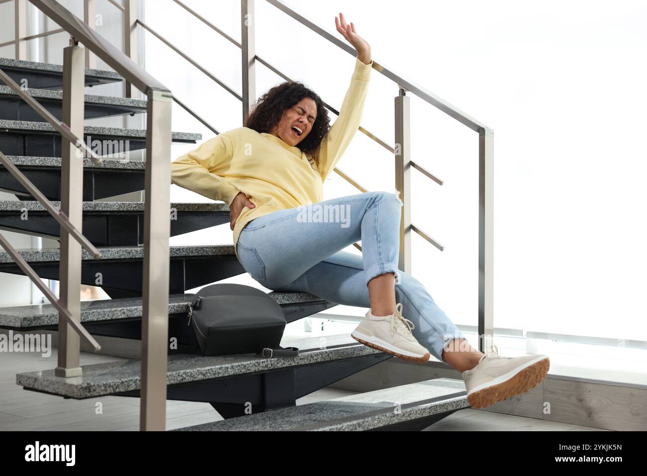 Injured woman on stairs in building after fall. Dangerous accident ...