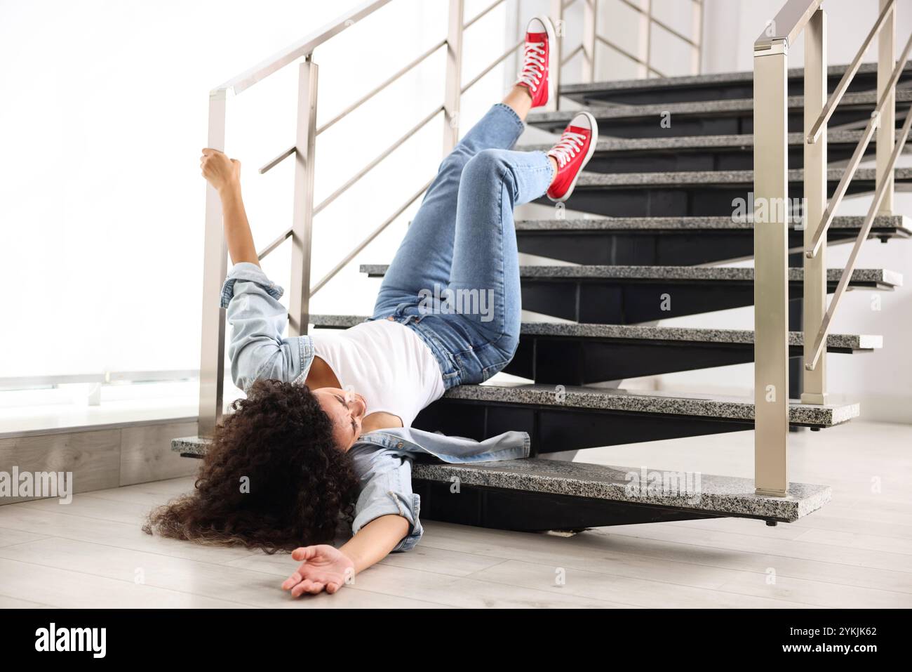 Injured woman on stairs in building after fall. Dangerous accident ...