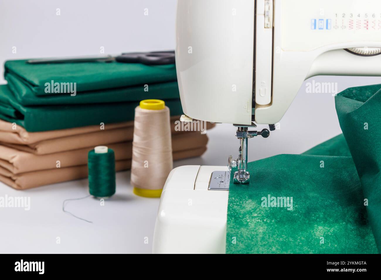 Sewing machine in action with fabric and threads on work table for crafting projects Stock Photo