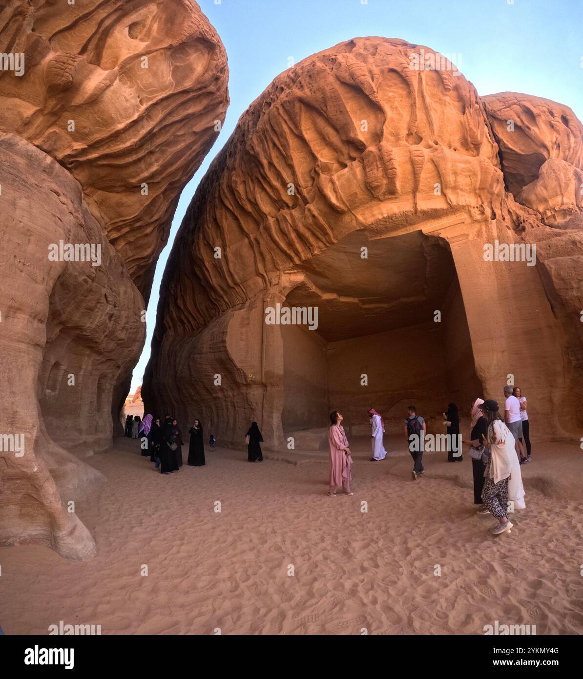 Mixed tourgroup visiting ancient Nabatean settlement of Jabar Ithlib, Hegra Archaeological Site (al-Hijr / Madā ͐ in Ṣāliḥ), in the desert near Al Ula Stock Photo