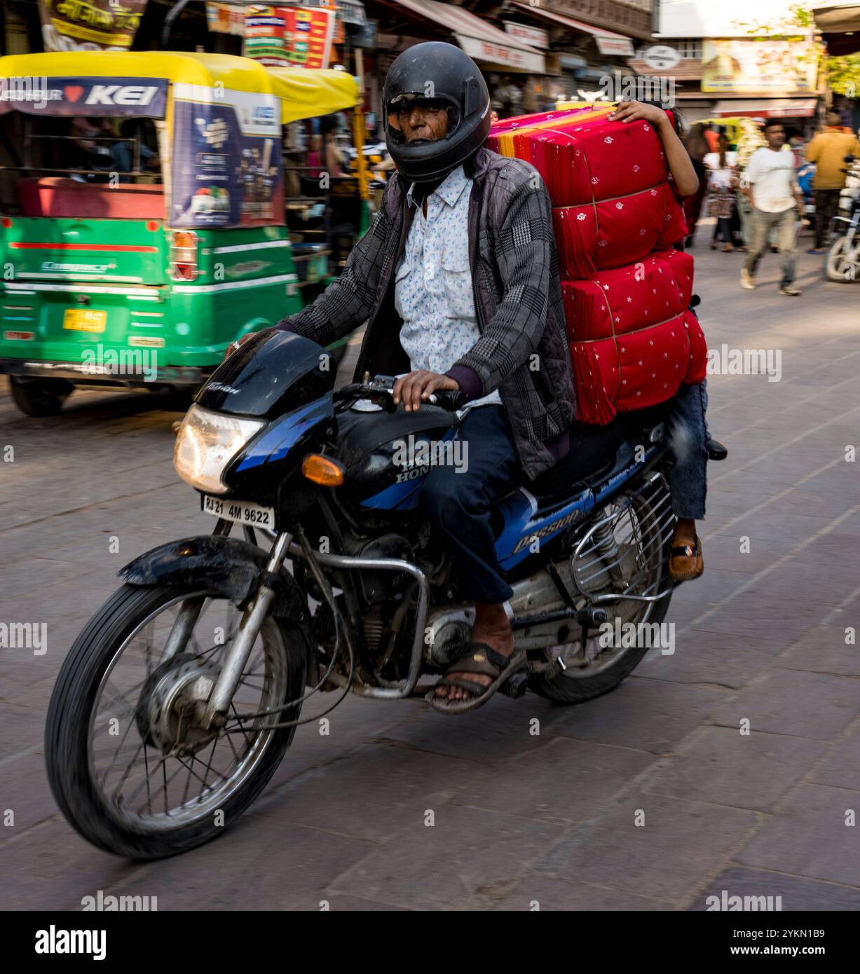 Dedicated courier transports a stack of red parcels on a motorcycle ...