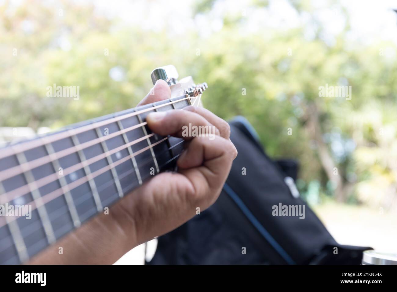 Guitar player strums the acoustic instrument, their fingers moving skillfully to create a melody filled with rhythm and notes, bringing warmth and har Stock Photo