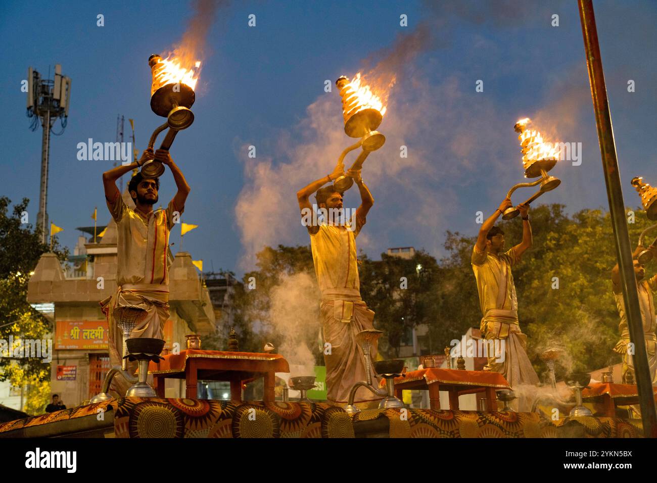 Priests perform the grand ganga aarti ritual with flaming lamps at dusk ...