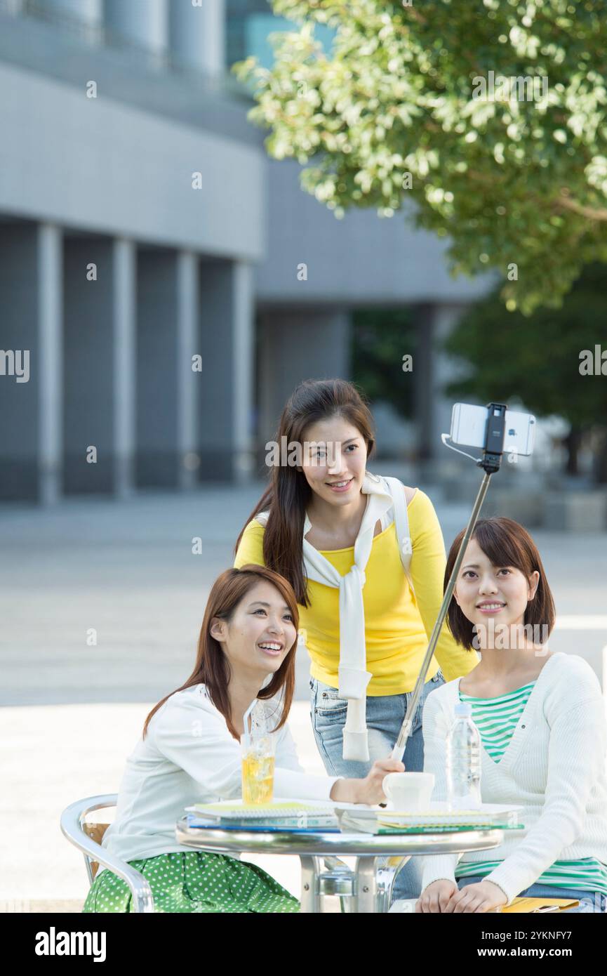 Three smiling university students in the campus cafeteria. Stock Photo