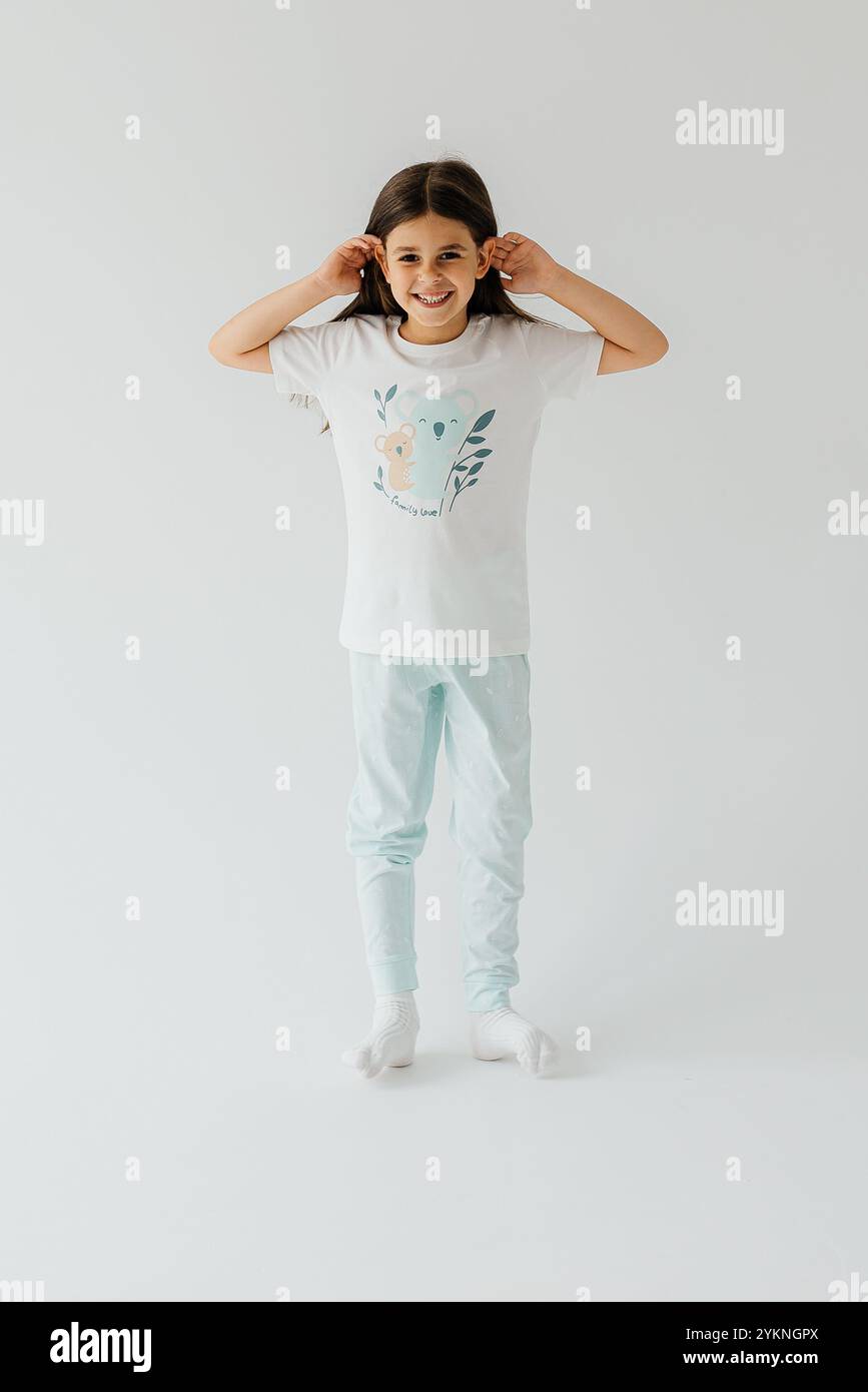 Cute girl wearing pajamas on white background Stock Photo - Alamy
