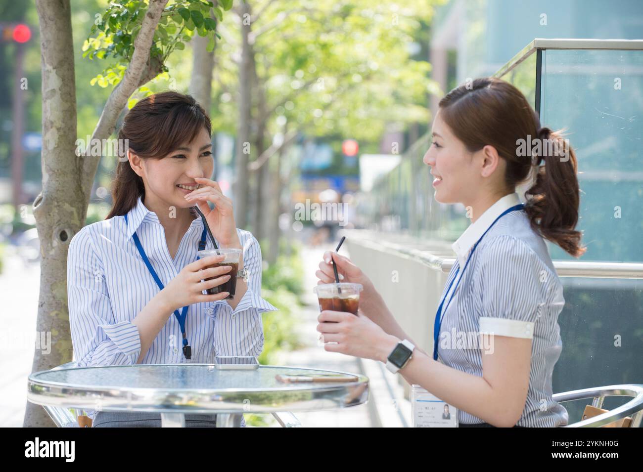Two office workers drinking iced coffee outdoors Stock Photo