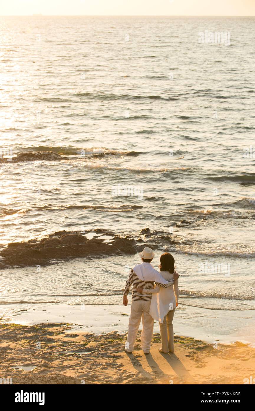 Middle-aged couple watching the sunset on the beach Stock Photo - Alamy
