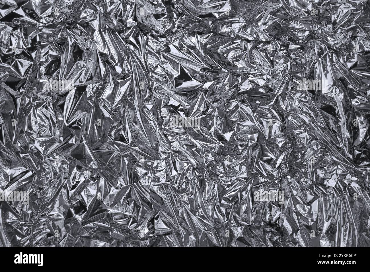 Fullframe crumpled silver foil shining texture background. Stock Photo