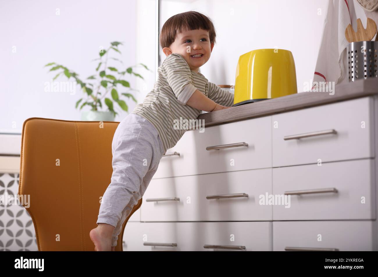 Little boy playing with toaster in kitchen. Dangerous situation Stock ...