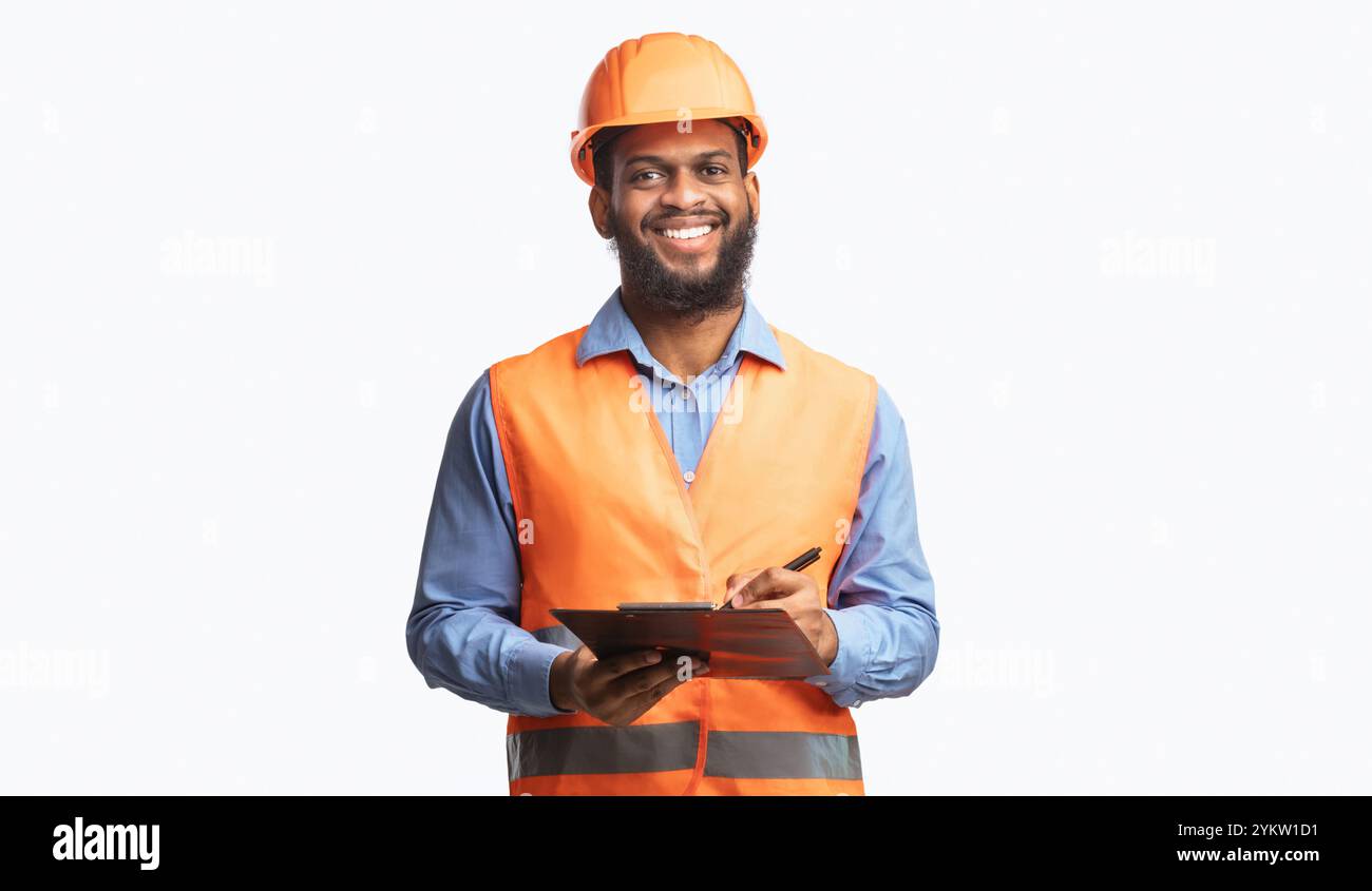 Happy Construction Worker Guy Taking Notes Holding Folder, Studio Shot Stock Photo