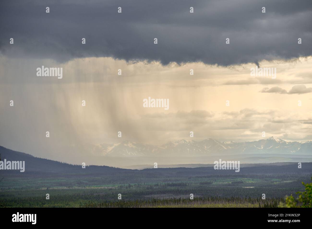 Moody and dark rain shower with storm clouds over a mountain scene ...