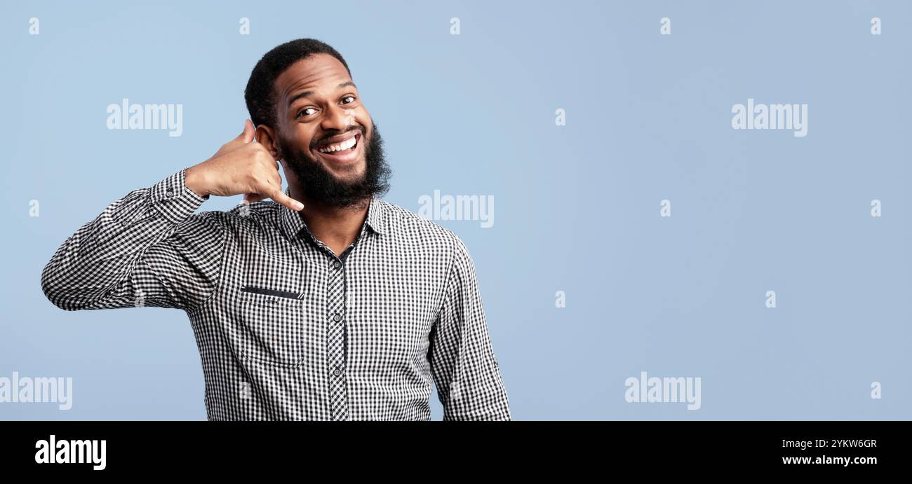 Afro man doing phone gesture at studio Stock Photo