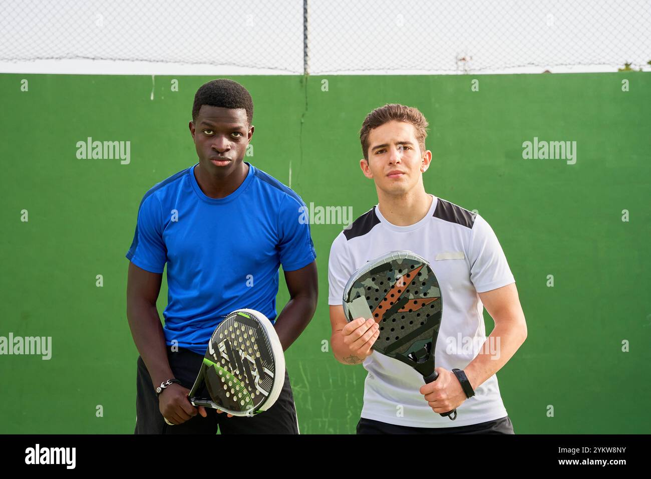 Two men are posing for a picture with their paddle tennis rackets Stock ...