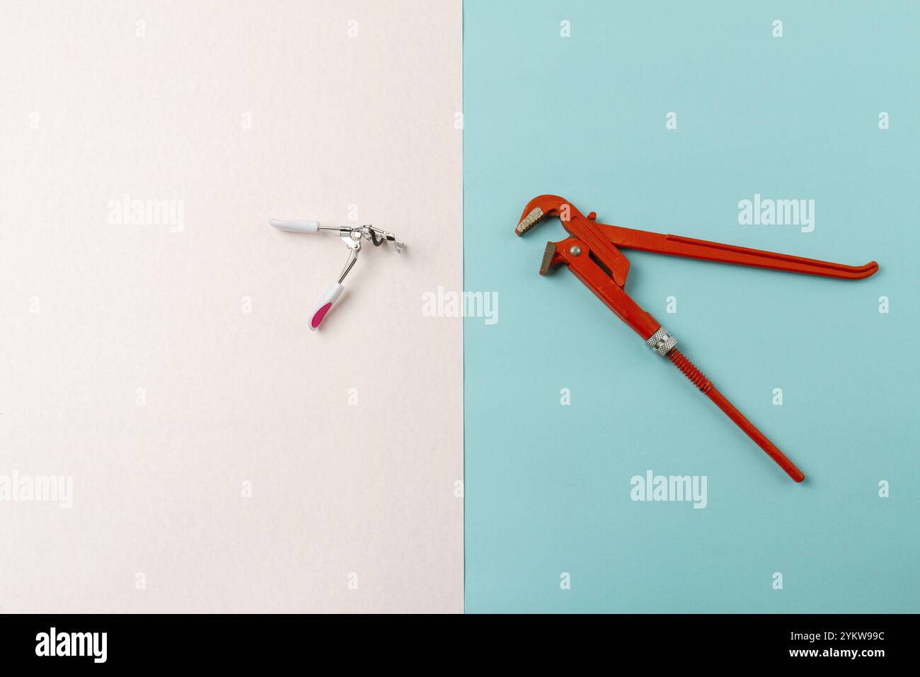 Top view contrast of mens and womens tools. Red adjustable wrench. White and turquoise surface Stock Photo