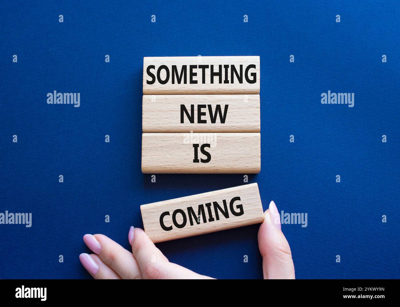 Smth New is coming symbol. Wooden blocks with words Something New is coming. Beautiful deep blue background. Businessman hand. Business and Something Stock Photo