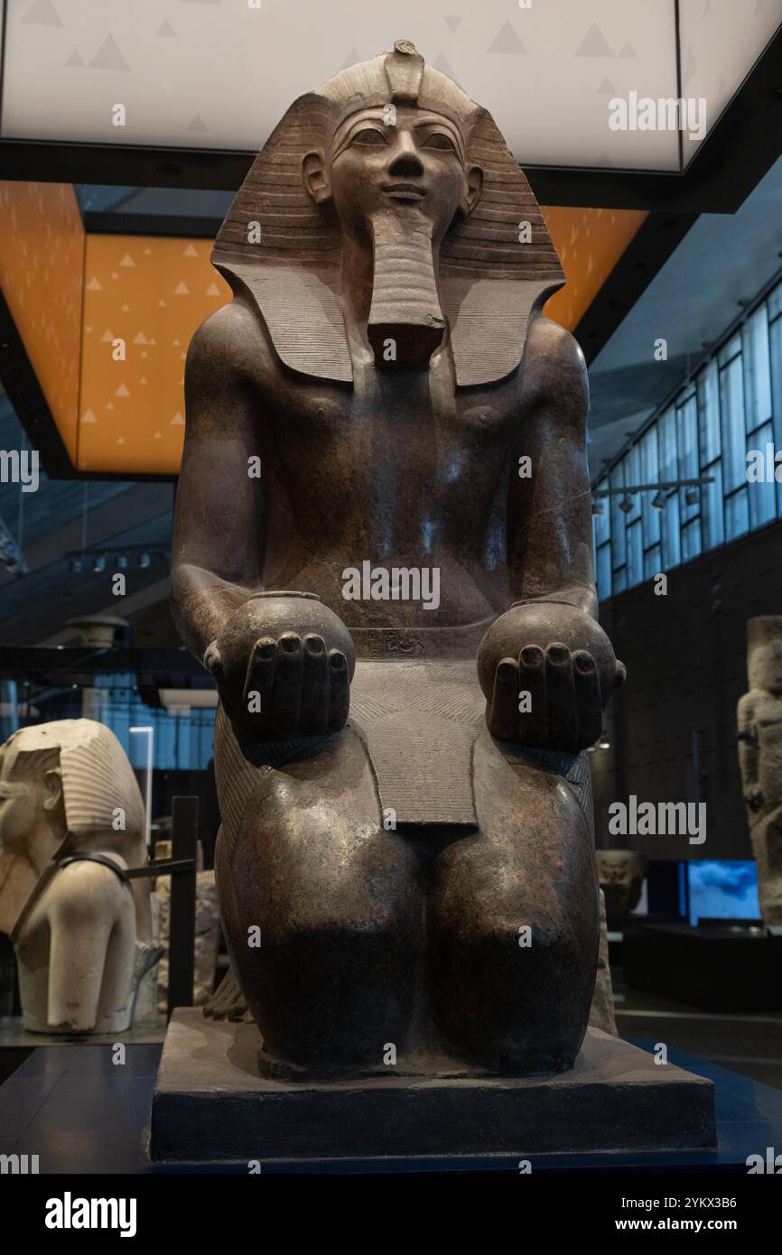 Large granite statue of a kneeling Queen Hatshesput offering 'nu' pots displayed in the recently-opened Grand Egyptian Museum (GEM) in Cairo, Egypt. Stock Photo