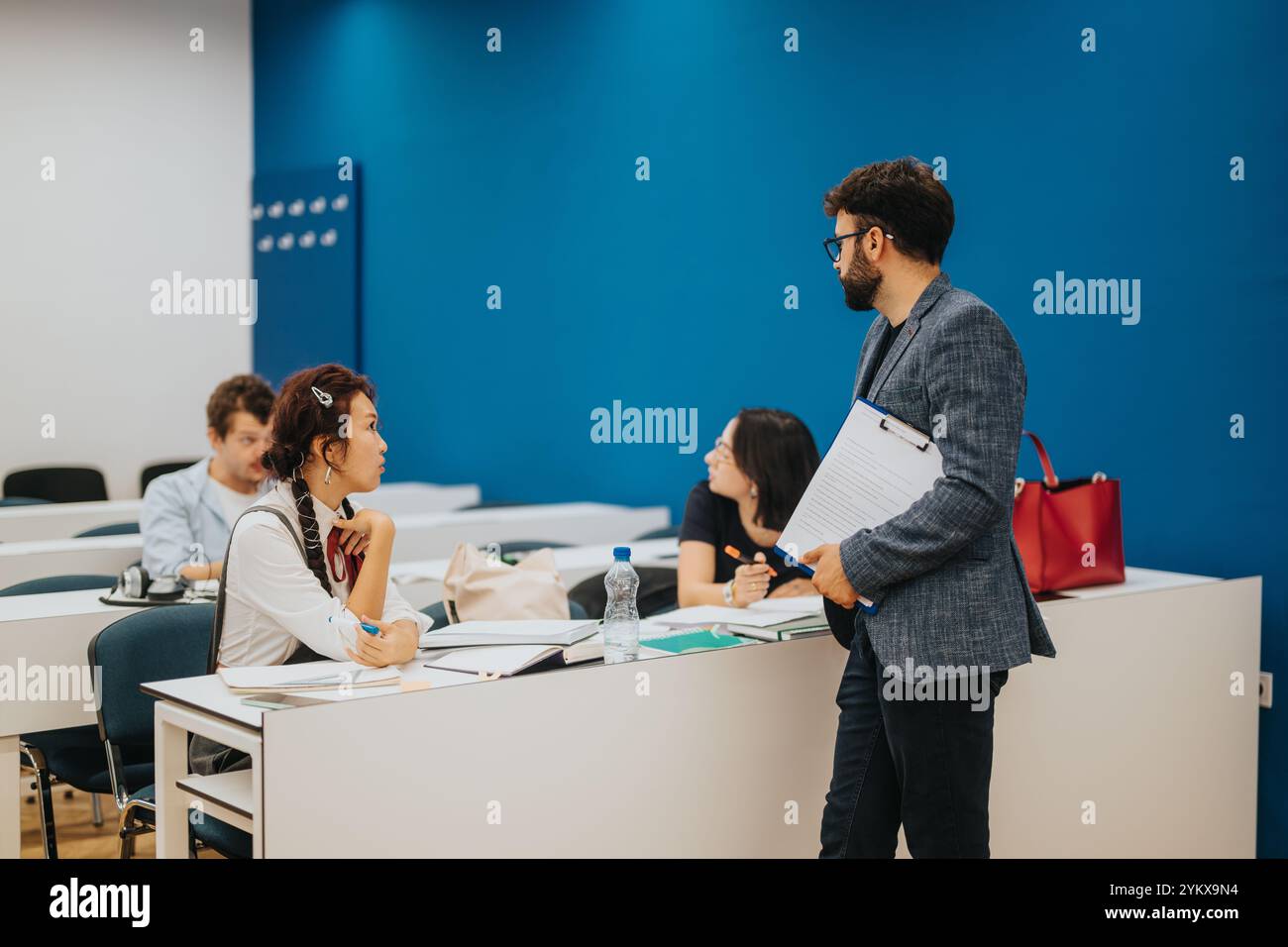 Professor assisting students during an interactive classroom session Stock Photo