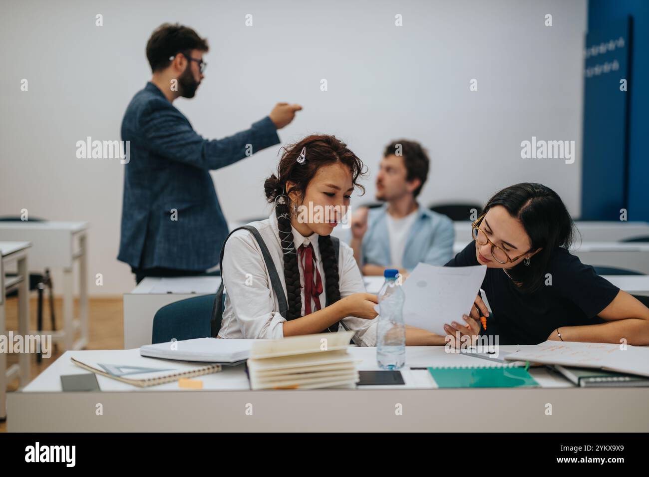 Professor assisting students during interactive classroom session Stock Photo