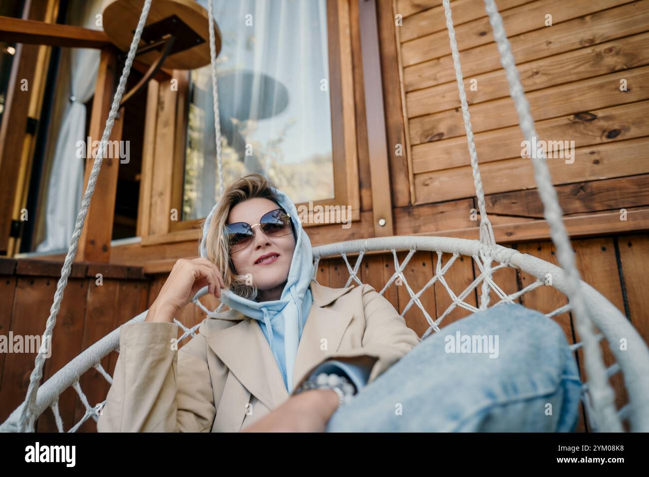 Woman Relaxing in a Hanging Chair with a View Stock Photo - Alamy