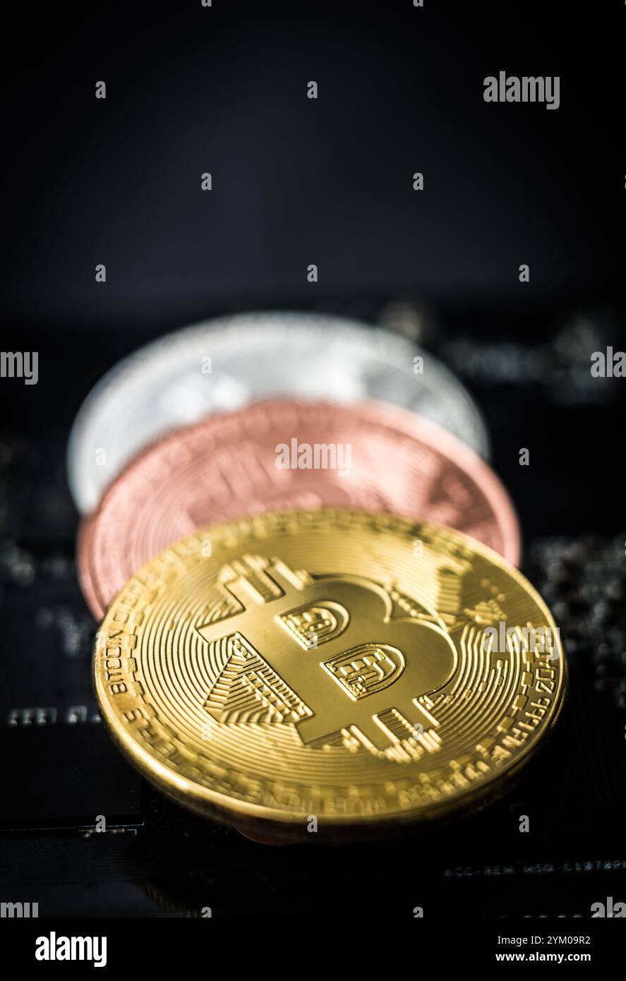 Coins of bitcoin on dark background. Golden bitcoin, silver bitcoin, bronze bitcoin on lying on grey background, close-up Stock Photo