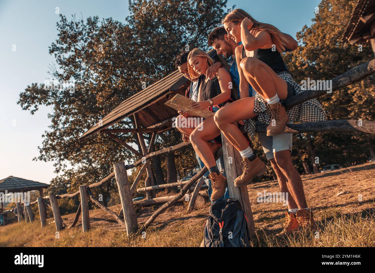 Group of four friends having fun hiking through forest together. Stock Photo