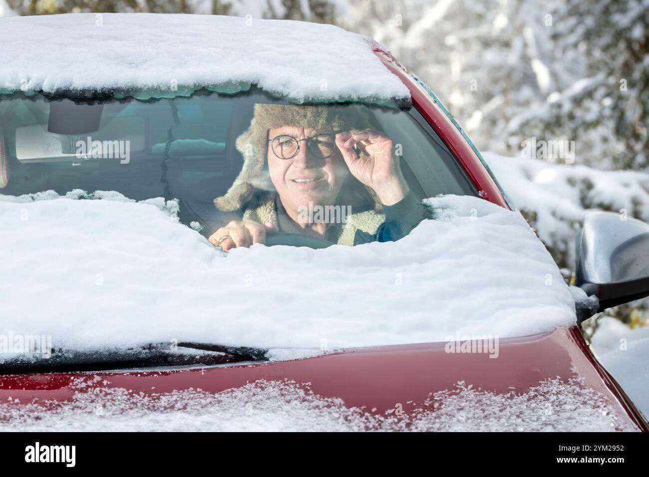 Wintereinbruch, Autofahrer will morgens nach Schneefall starten, hat Windschutzscheibe nur halb vom Schnee befreit, schlechte Sicht, München, 20. November 2024 Deutschland, München, November 2024, Wintereinbruch, Auto eingeschneit, Rentner hat die Autoscheiben nur notdürftig vom Schnee befreit, Windschutzscheibe und Autodach teils noch schneebedeckt, schlechte Sicht, er friert im Auto, Autoheizung funktioniert noch nicht, Glättegefahr, Wintereinbruch, Winterwetter, Winter, Bayern, *** Onset of winter, car driver wants to start in the morning after snowfall, has only half cleared the windshield Stock Photo
