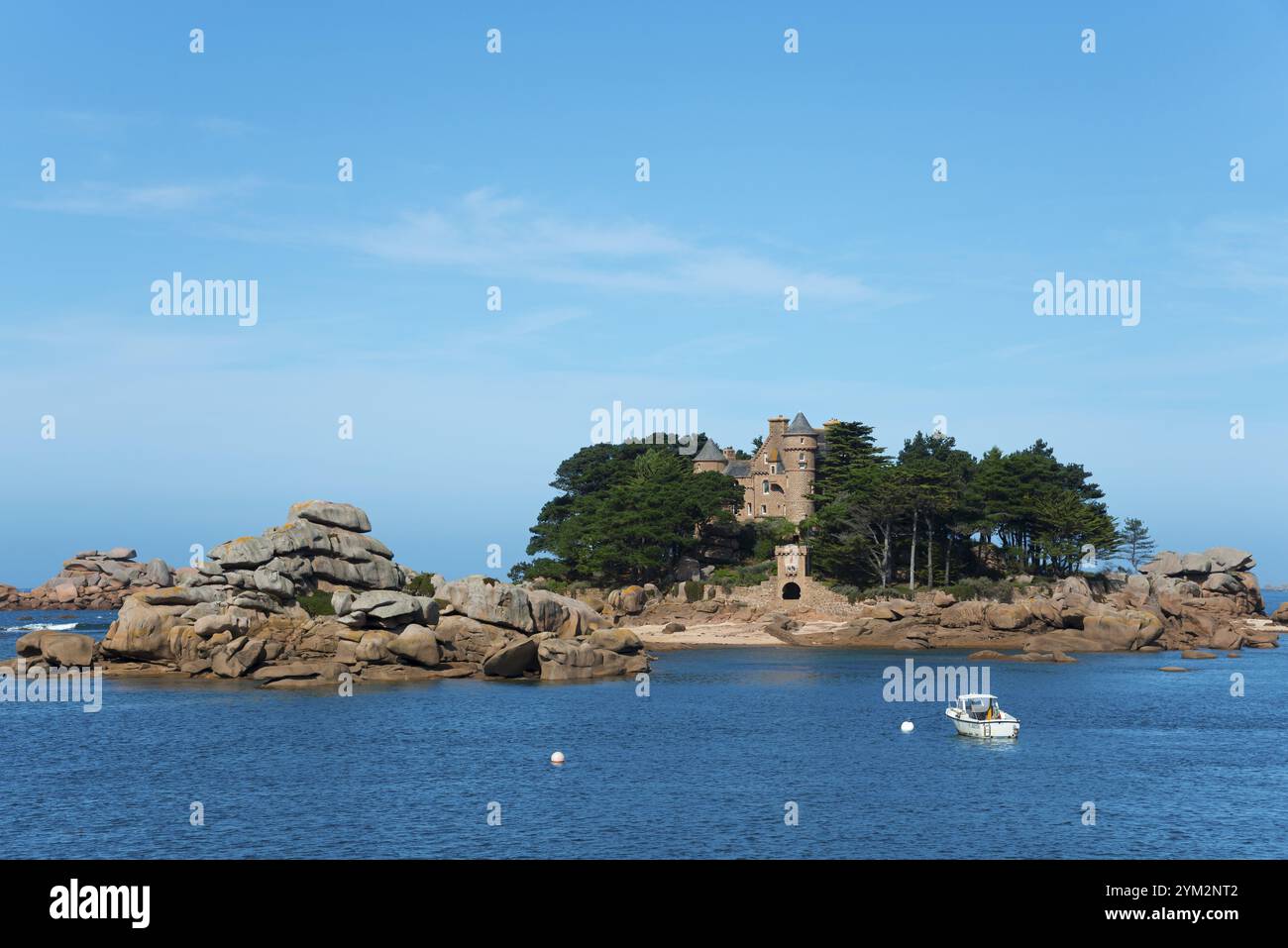 Rocky island with historic architecture and trees, surrounded by blue ...