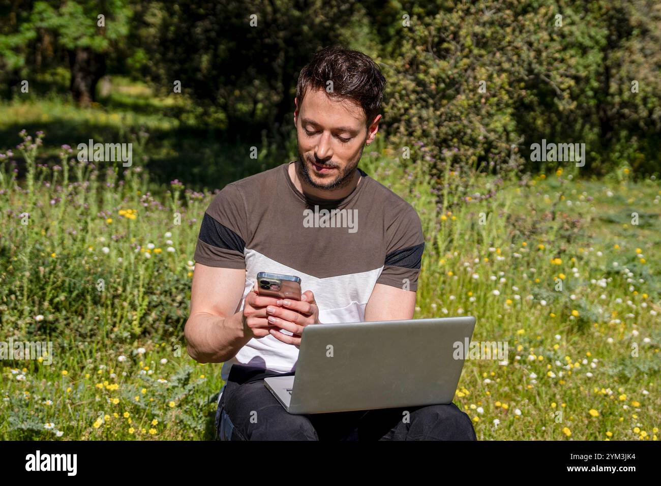 Digital Nomad: Young Man Backpacker Using Laptop and Phone Stock Photo