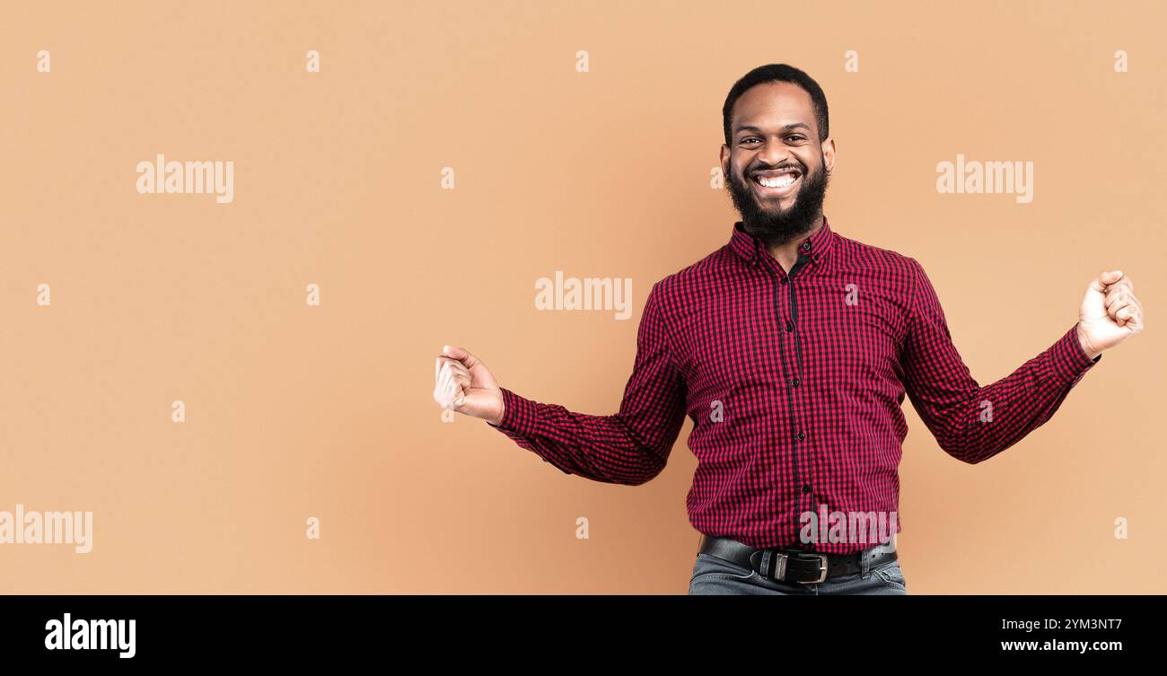 Happy black guy jumping and looking at camera Stock Photo