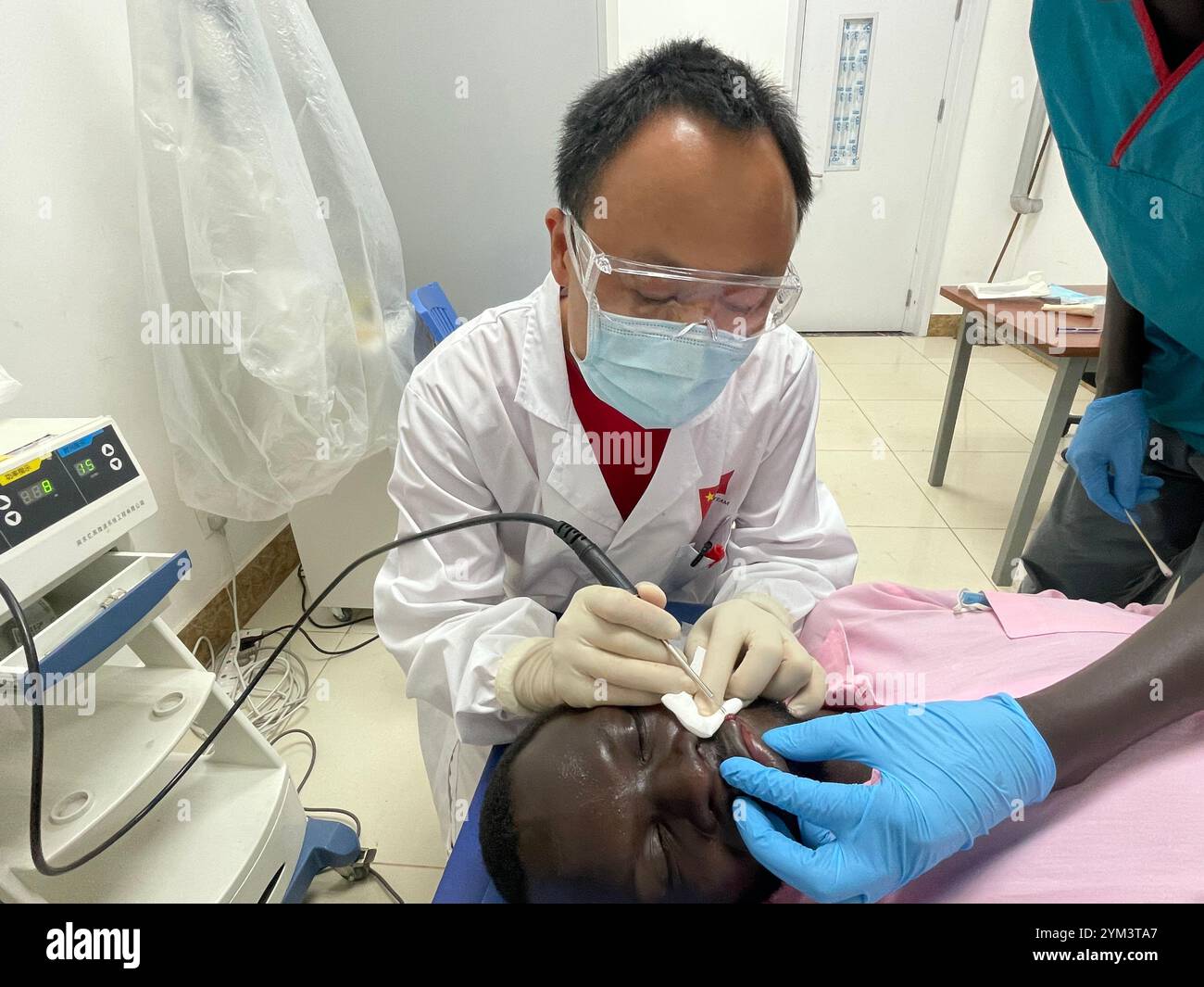 Juba, South Sudan. 8th Nov, 2024. Chinese dermatologist Zheng Jianfeng operates on a South Sudanese patient at the Juba Teaching Hospital in Juba, South Sudan, on Nov. 8, 2024. Patients with fungal skin infections in South Sudan are increasingly flocking to the Juba Teaching Hospital, drawn by the expertise of Zheng Jianfeng, a Chinese dermatologist from the 12th batch of the Chinese medical team stationed in the country. Credit: Denis Elamu/Xinhua/Alamy Live News Stock Photo