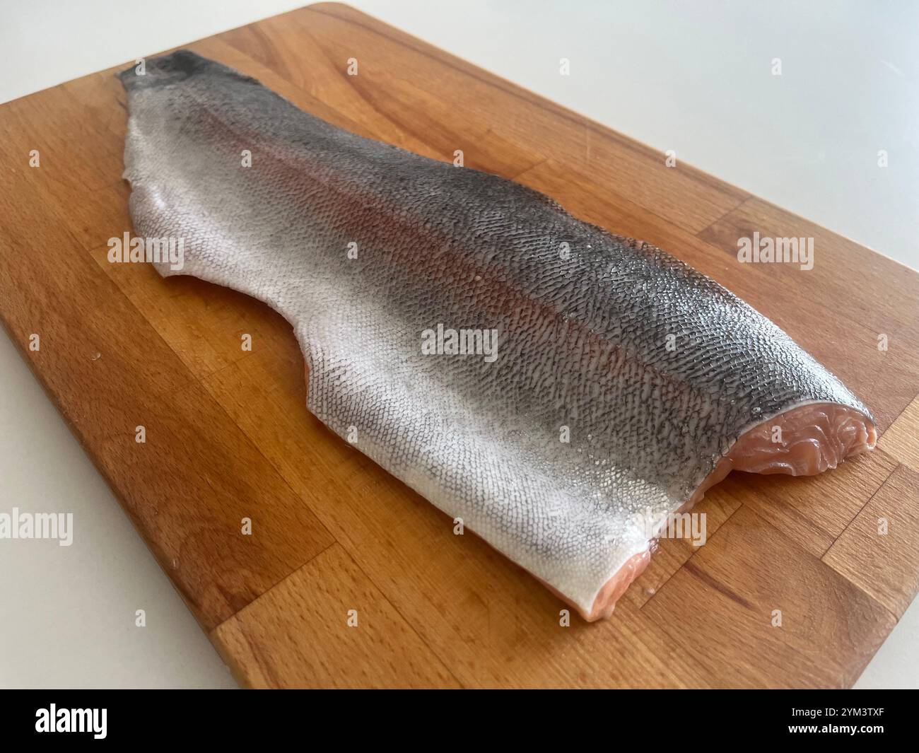 Sea Trout fish fillet on wooden cutting board as home fish cooking preparation - Smartphone Captured Stock Image