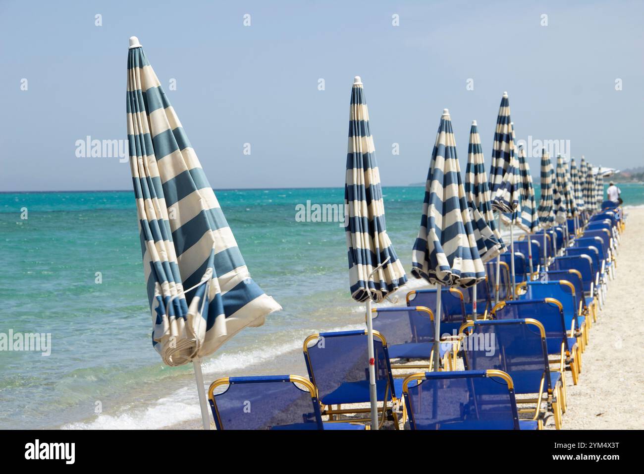 The beach with empty deckchairs and the vintage umbrellas Stock Photo