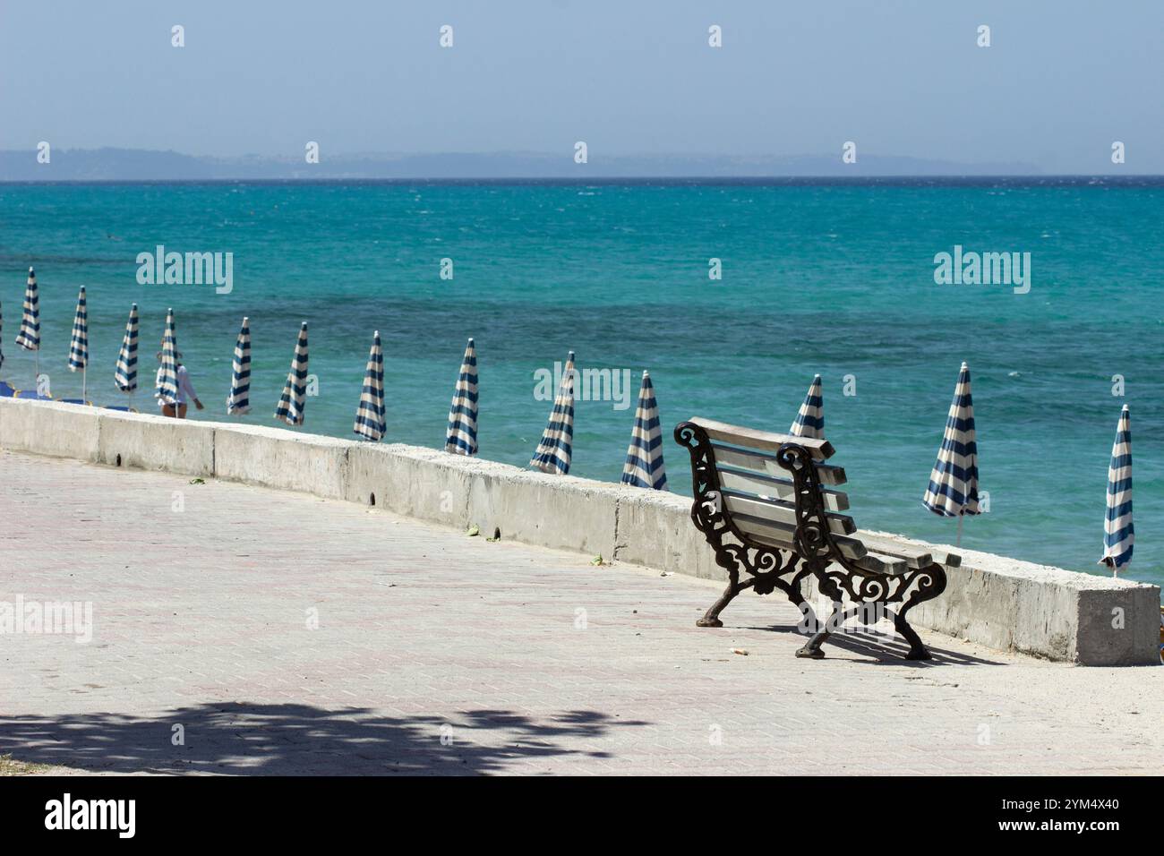 Seascape with a vintage bench and umbrellas Stock Photo