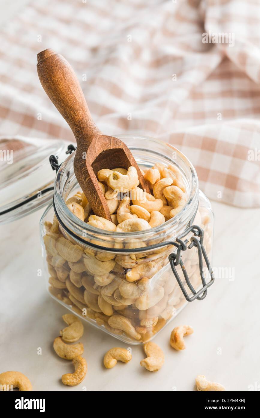 Roasted cashew nuts in jar on a kitchen table. Stock Photo