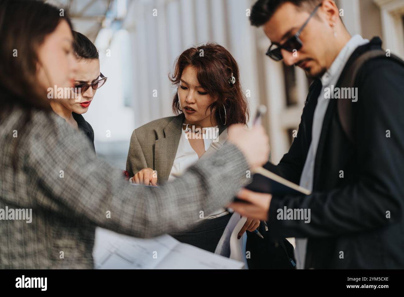 Multicultural business team collaborating on project outdoors Stock Photo