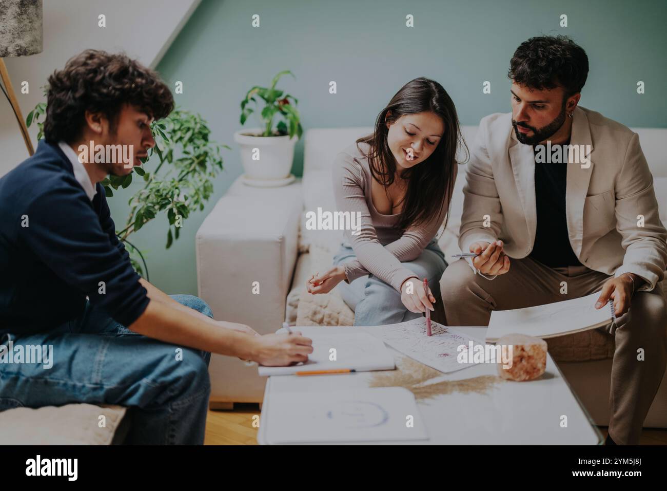Students collaborating on a creative project in a modern room Stock Photo
