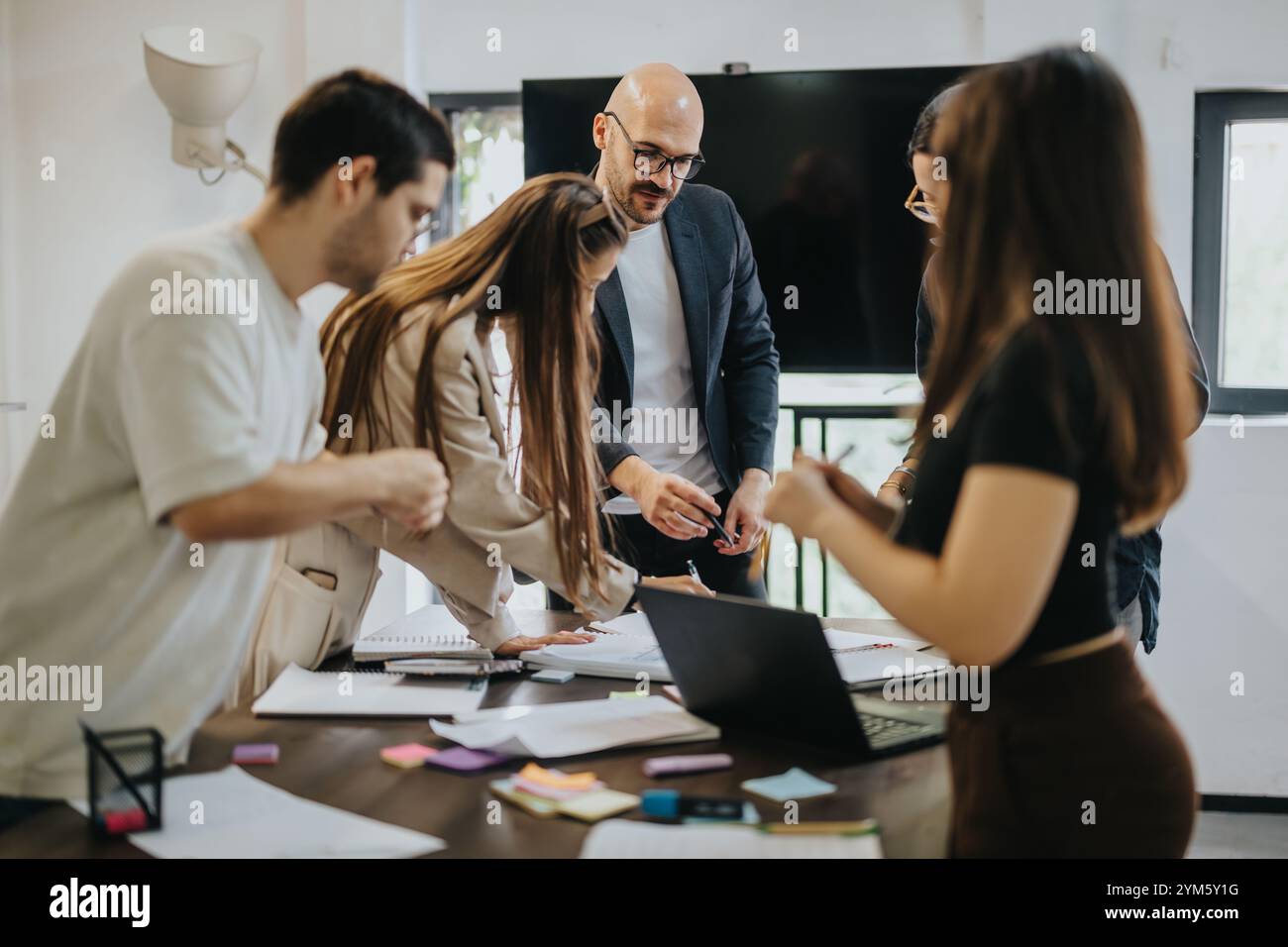 Students collaborating on a project with guidance from their professor Stock Photo