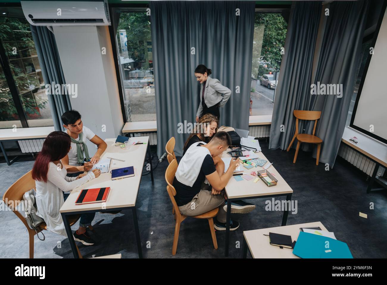 Students collaborating on a group project in modern classroom setting Stock Photo