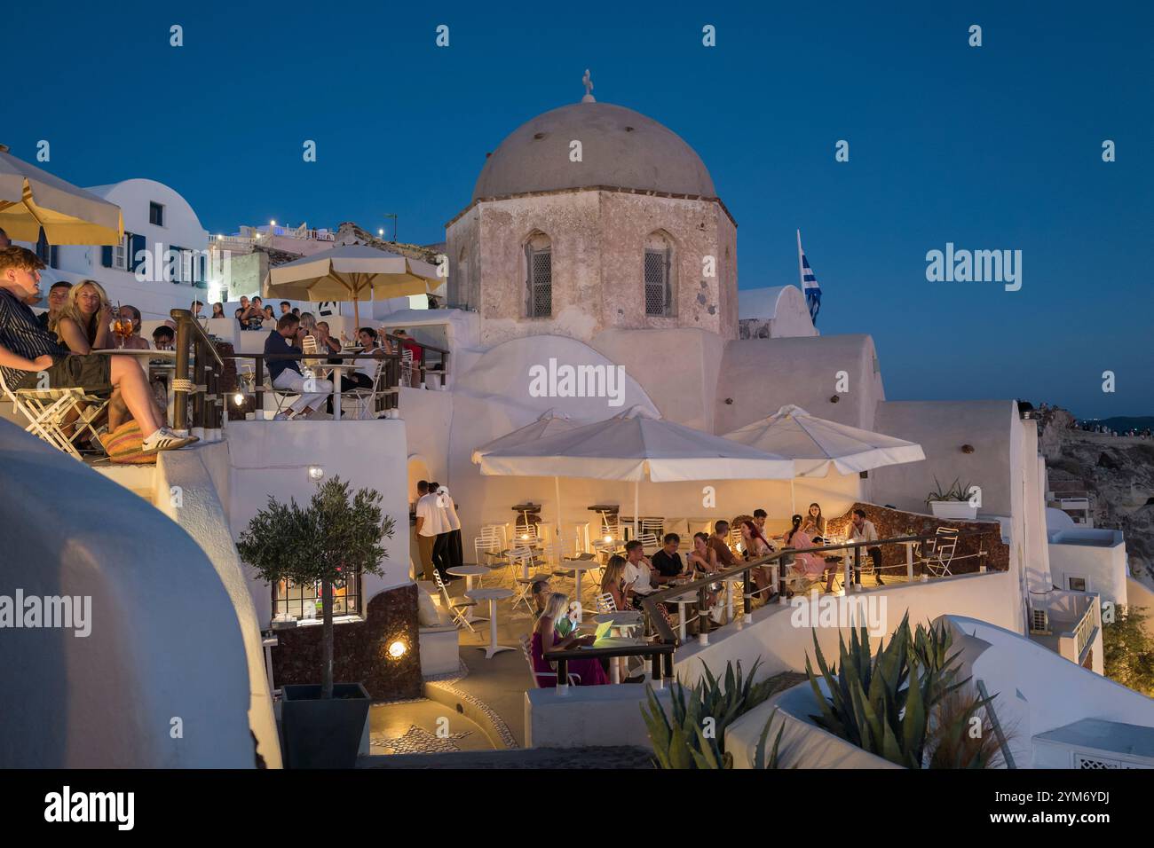 Tourists and locals dining at a restaurant in Oia, Santorini, Greece Stock Photo